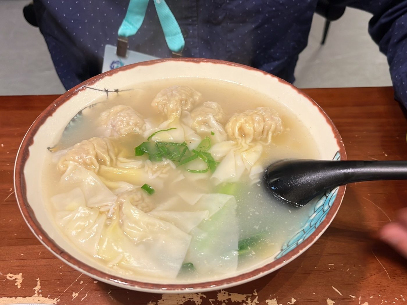 Wonton noodle soup in clear broth with greens