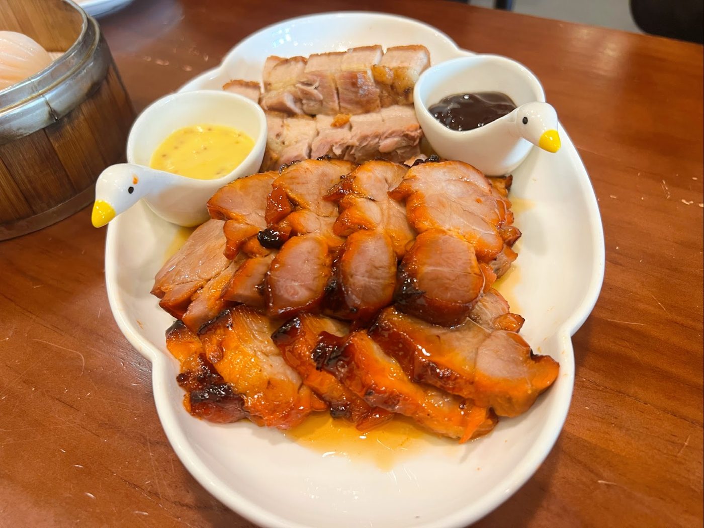 Char siu and crispy roast pork platter with dipping sauces